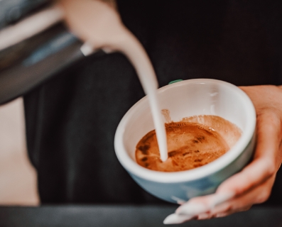 Barista vertiendo leche en café latte
