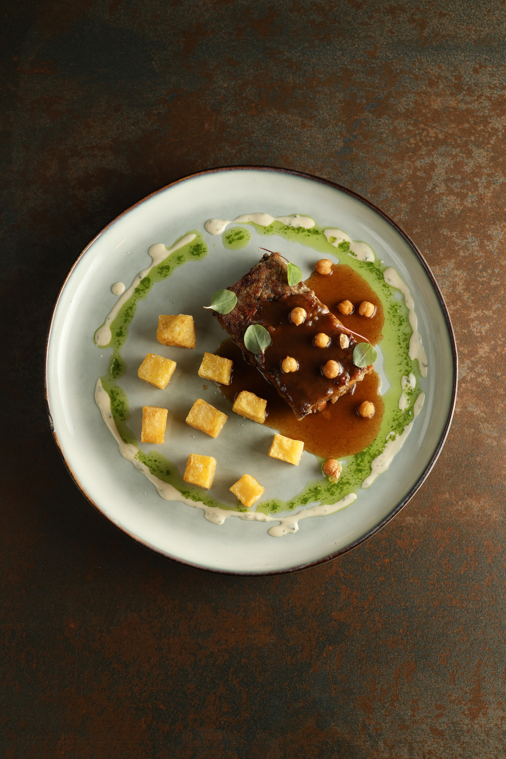 Emplatado gourmet con salsas y dados de carne